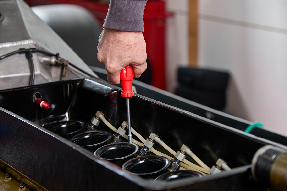 Boîte à outils avec tournevis rouge dans la main d'un mécanicien.