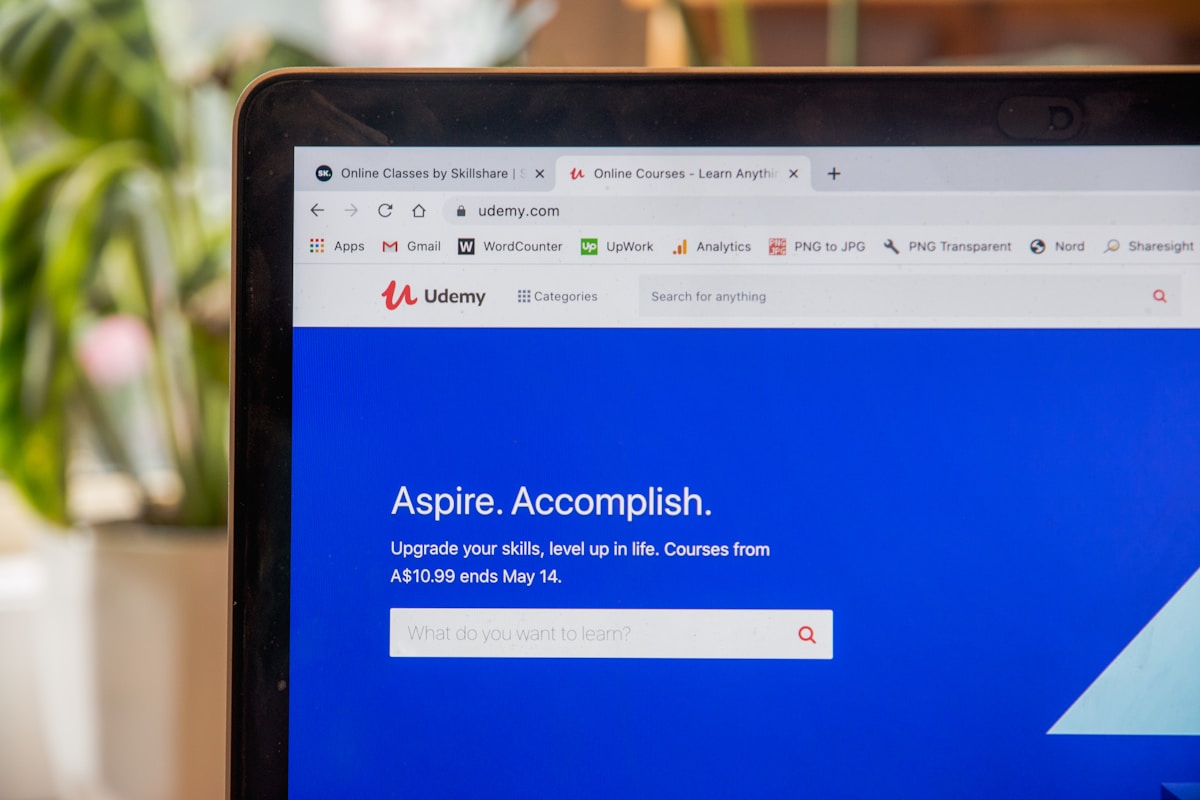 Écran d'ordinateur affichant la page d'accueil de Udemy avec l'offre "Aspire. Accomplish."
