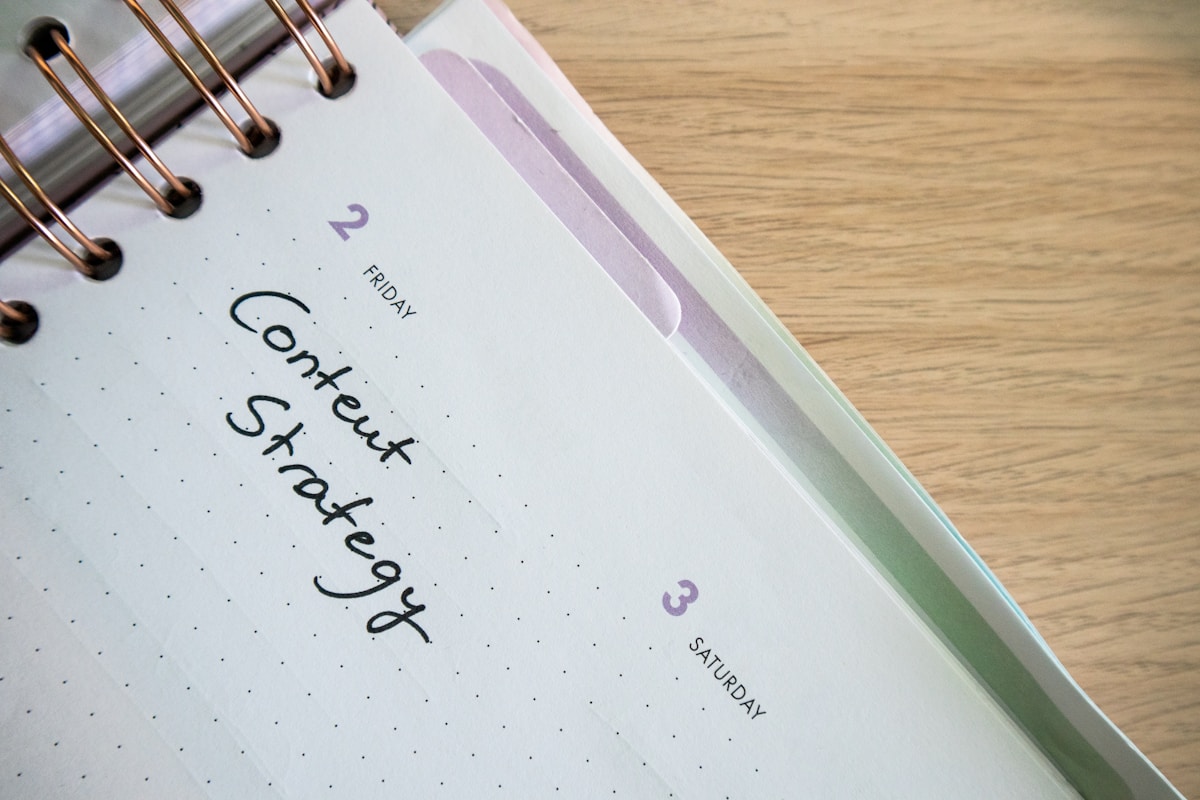 Agenda hebdomadaire avec texte "Content Strategy" sur une table en bois.