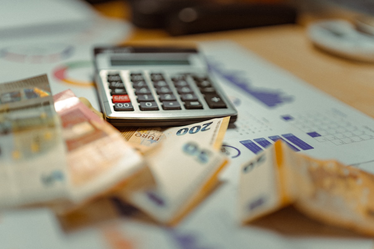 Calculatrice, billets de banque, graphiques financiers, analyse de données, gestion des finances.