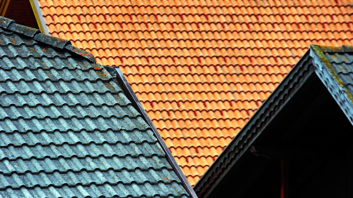Toits de tuiles orange et gris, motifs géométriques, architecture traditionnelle.