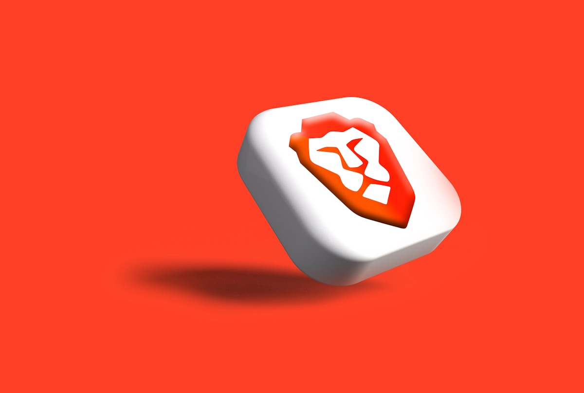 Cube blanc avec logo orange sur fond rouge vif.