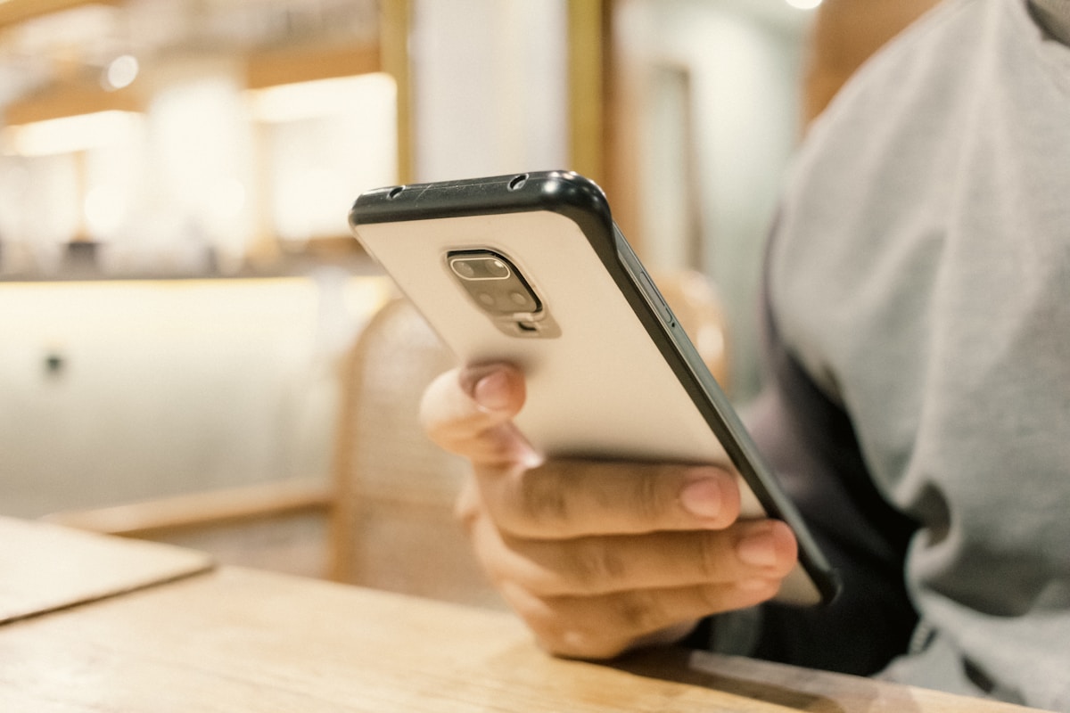 Gros plan sur un smartphone tenu dans les mains d'une personne.