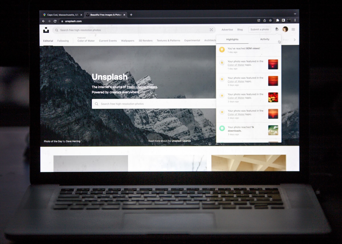 Paysage montagneux enneigé avec un site web Unsplash sur un ordinateur portable.