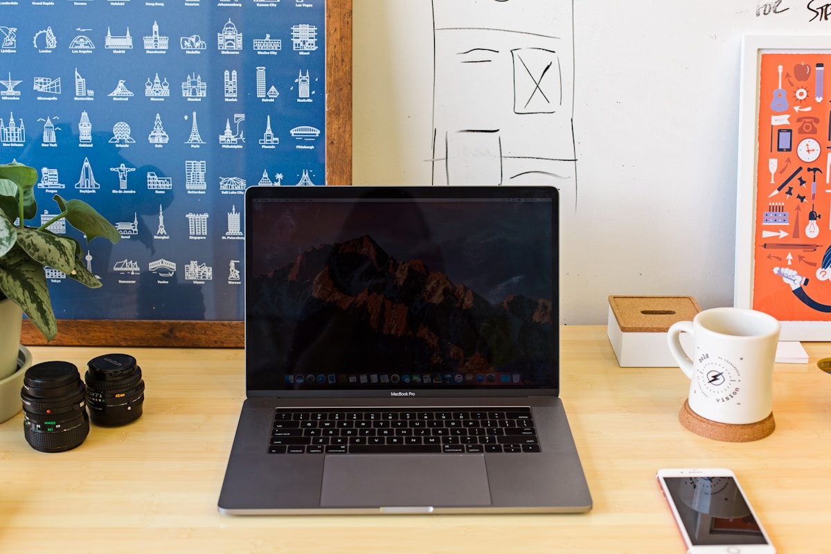 Bureau de travail avec ordinateur portable, appareils photo et accessoires.