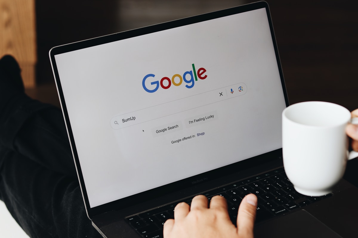 Écran d'ordinateur affichant la page d'accueil de Google avec une tasse de café.