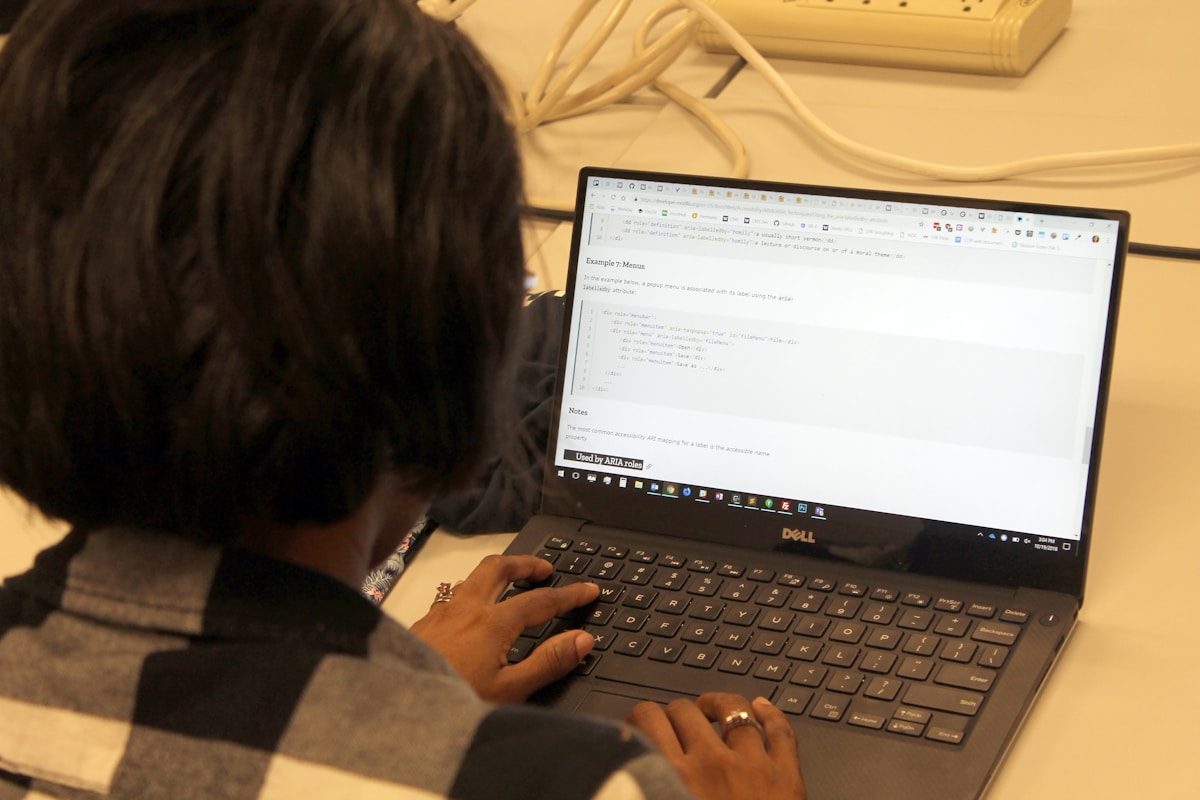Personne travaillant sur un ordinateur portable avec un code de programmation affiché à l'écran.
