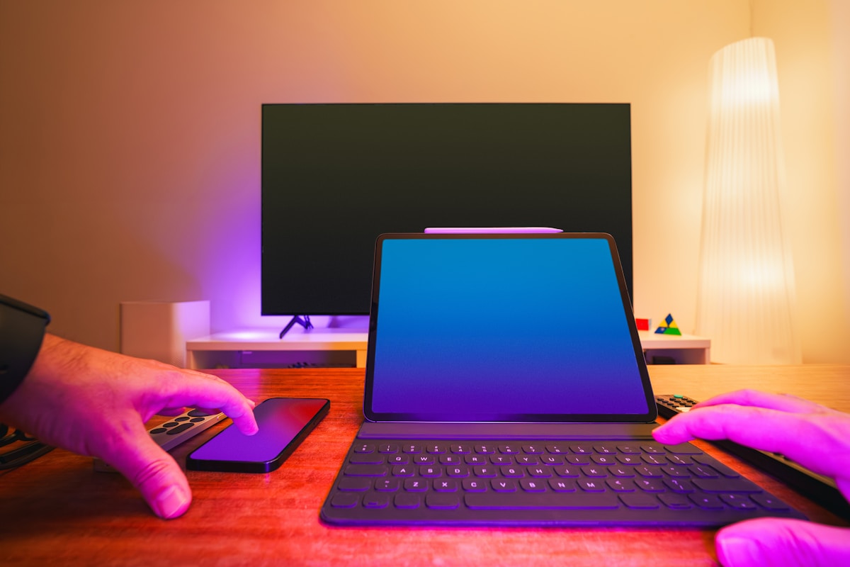 Tablette électronique avec clavier, manettes de jeu et écran de télévision allumé.