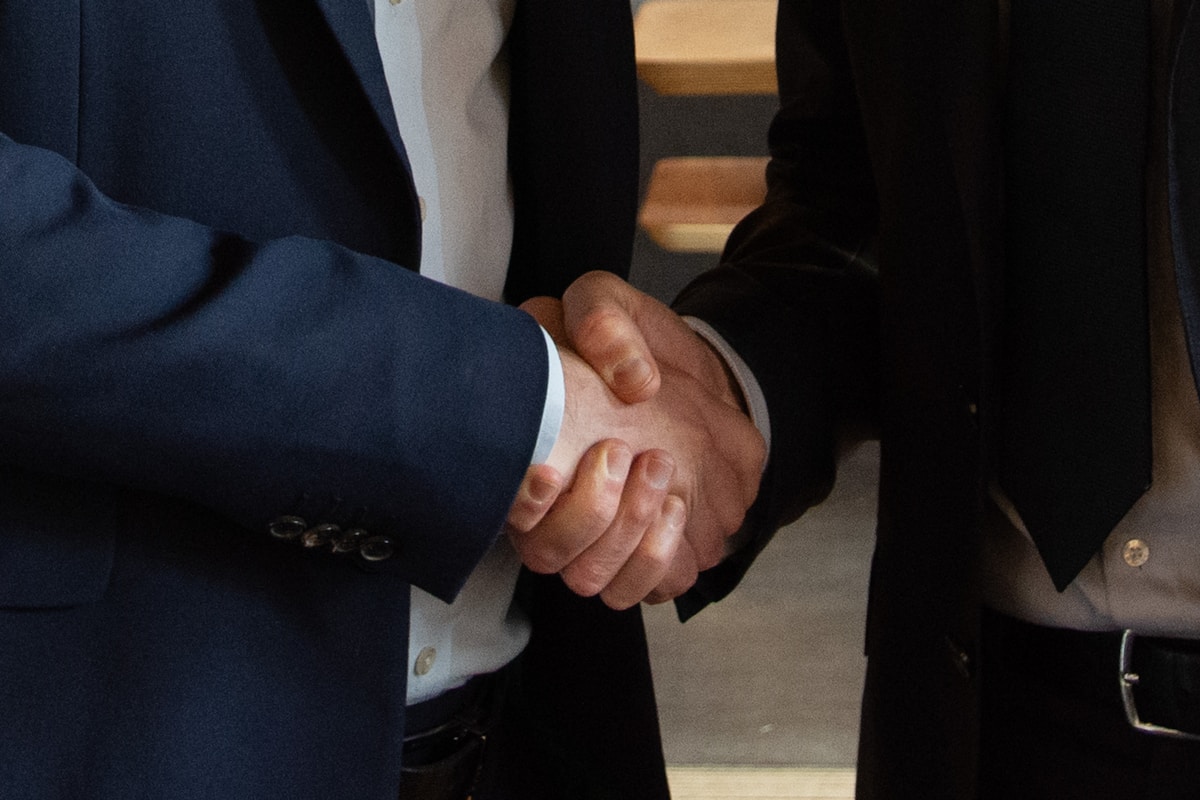 Poignée de main entre deux hommes d'affaires en costume.