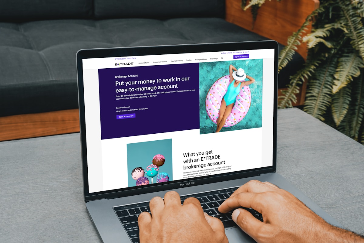 Ordinateur portable affichant le site Web d'un courtier en ligne avec des illustrations colorées.