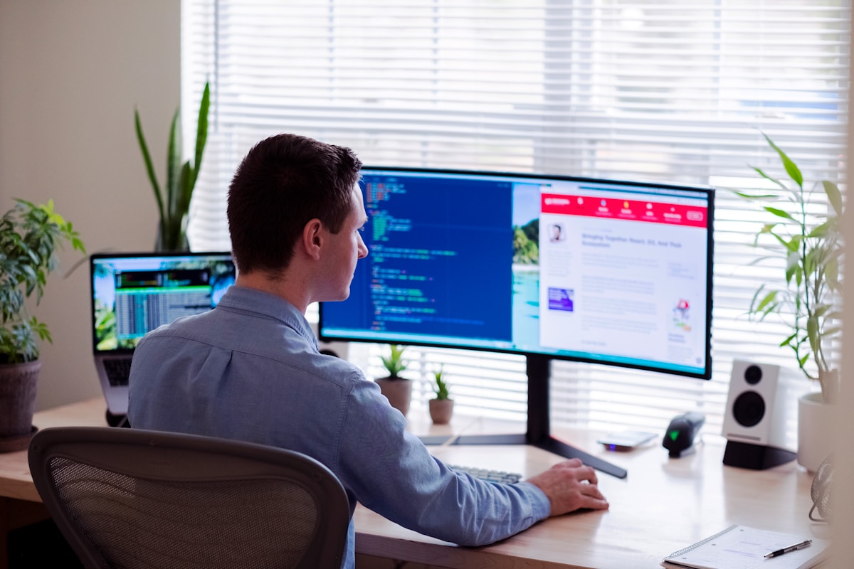 Homme travaillant sur des ordinateurs dans un bureau à domicile.