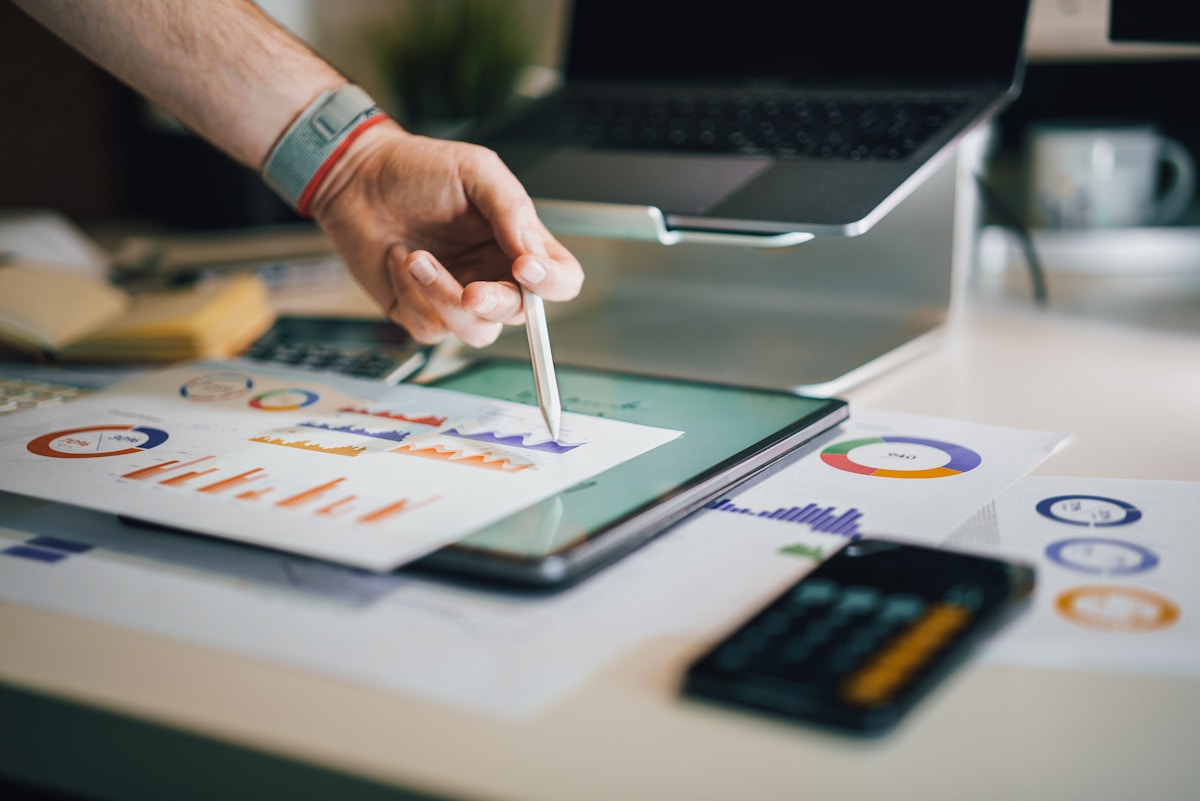 Analyse de données financières sur un bureau avec ordinateur portable.