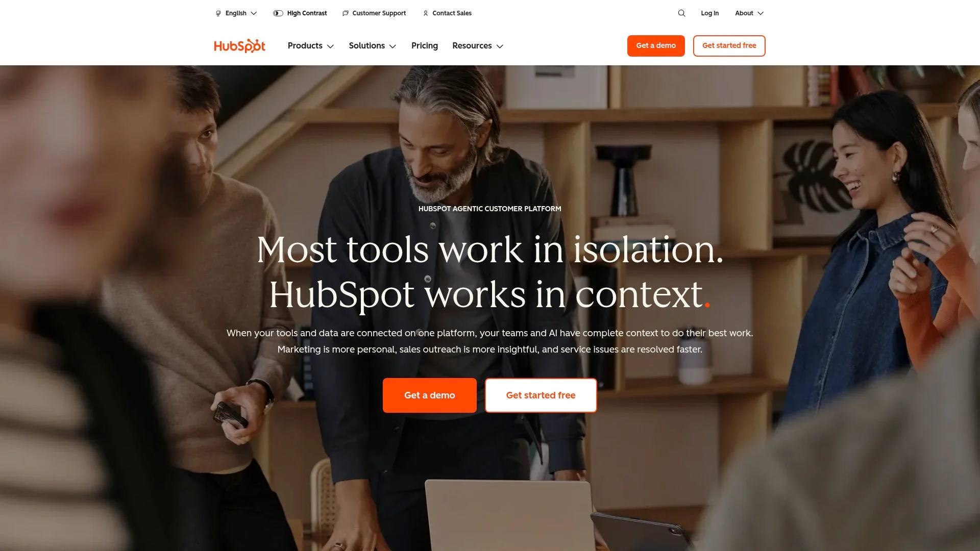 Trois personnes collaborant sur un ordinateur portable dans un environnement de travail.