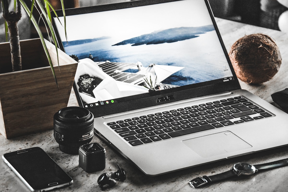 Ordinateur portable, objectif d'appareil photo, accessoires de photographie, paysage marin.