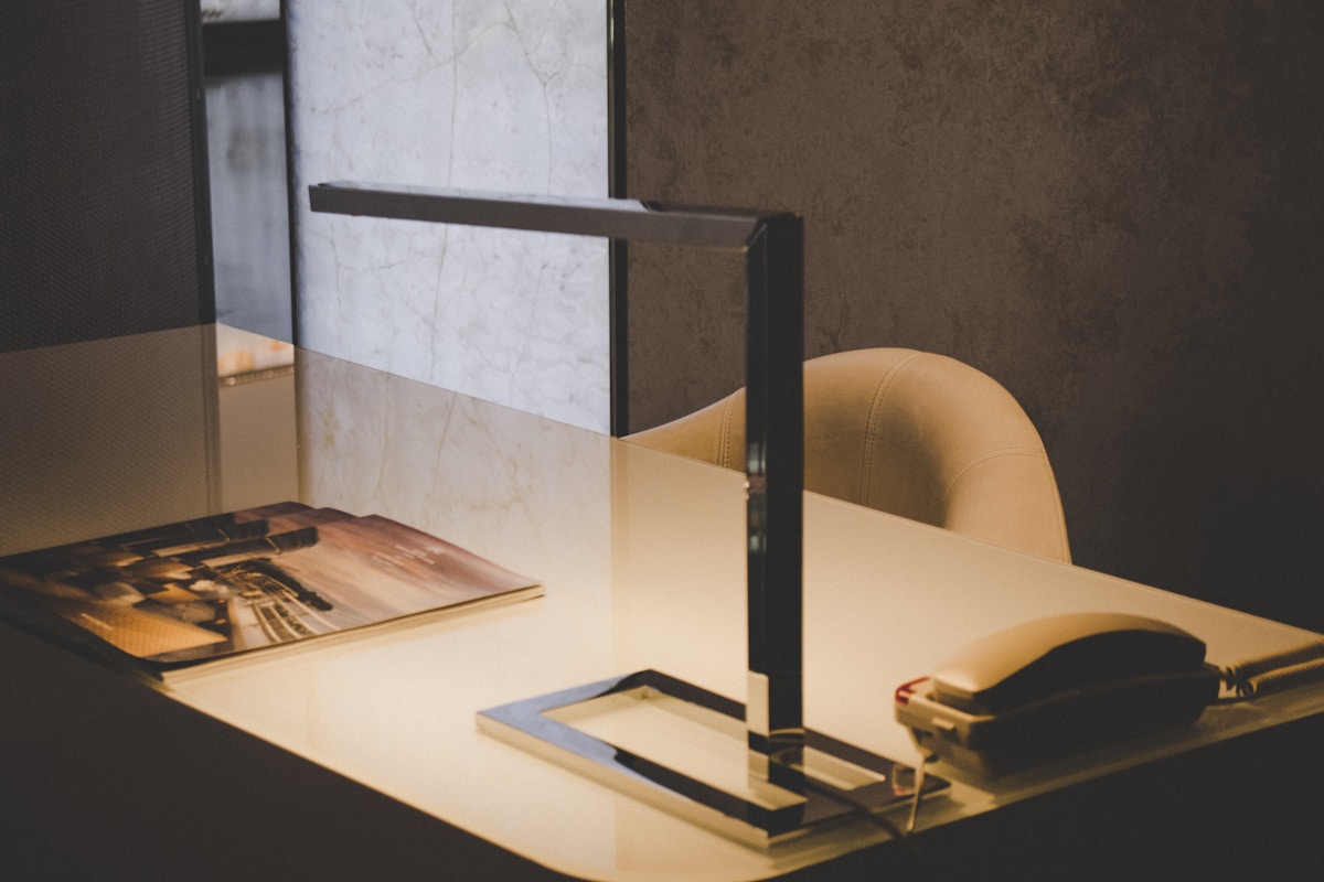 Bureau de travail avec lampe de bureau et documents.