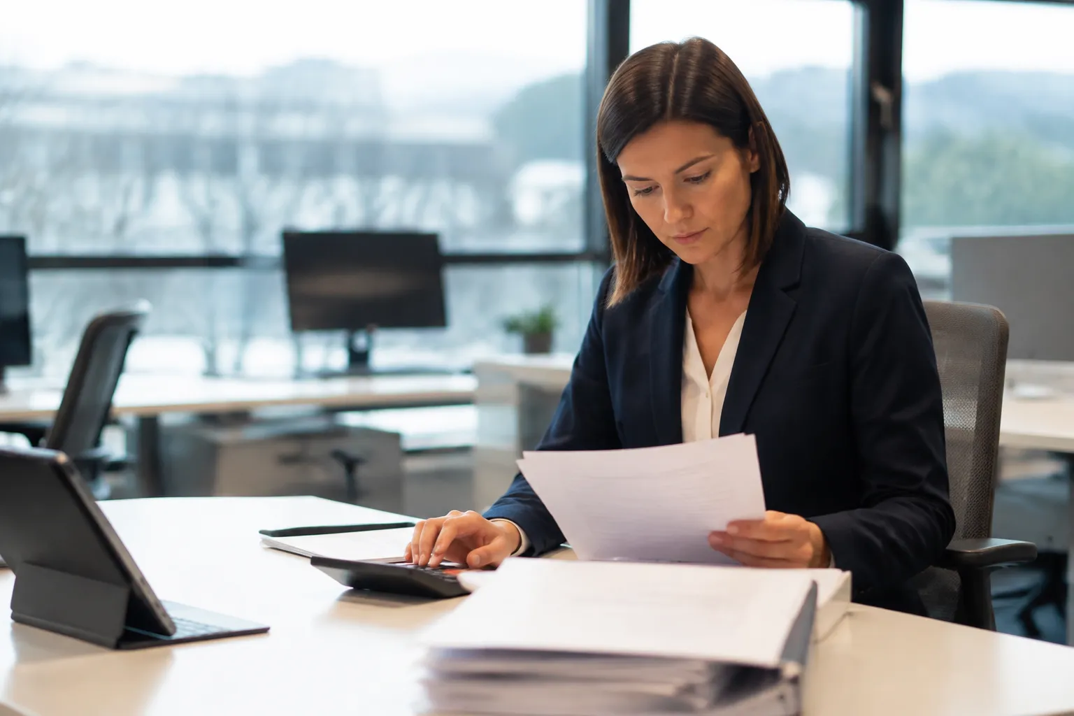 Femme d'affaires concentrée examinant des documents dans un bureau.