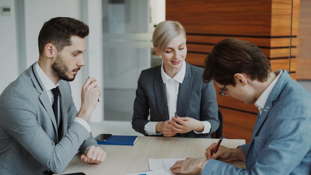 consultant en gestion fiduciaire - Business people signing a contract at a table.