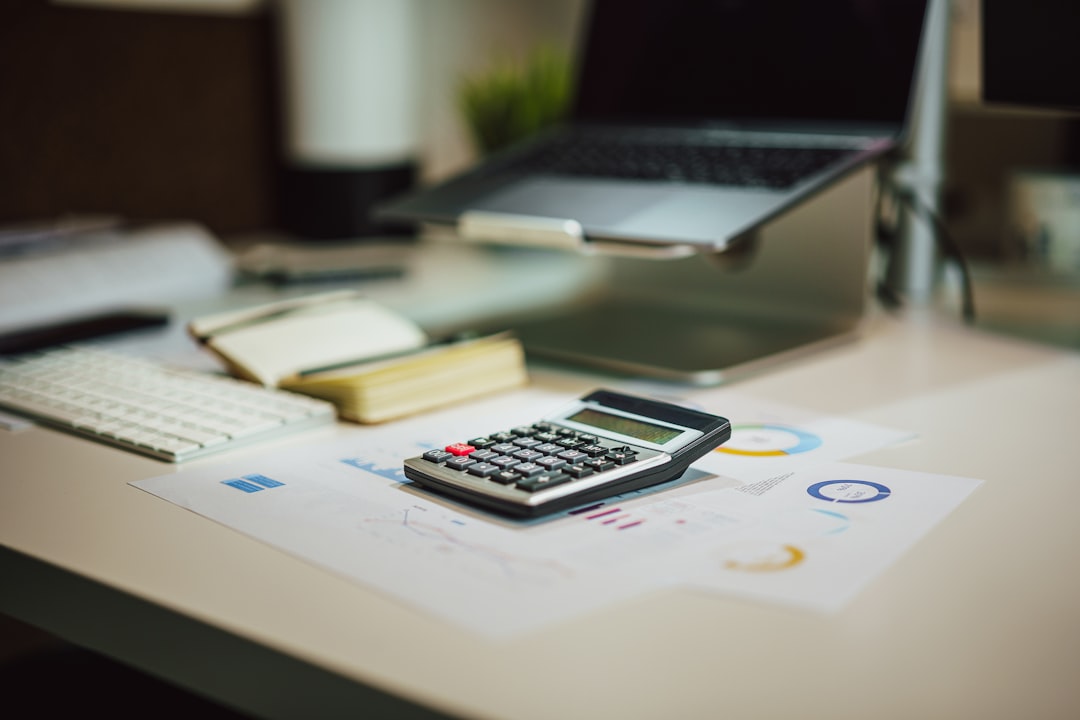 futur de la comptabilité fiduciaire suisse - a calculator sitting on top of a table next to a laptop