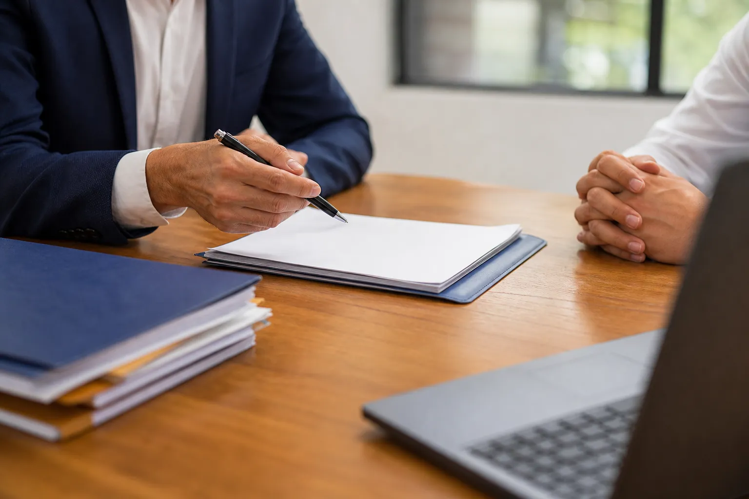 Homme d'affaires signant un document sur un bureau en bois.