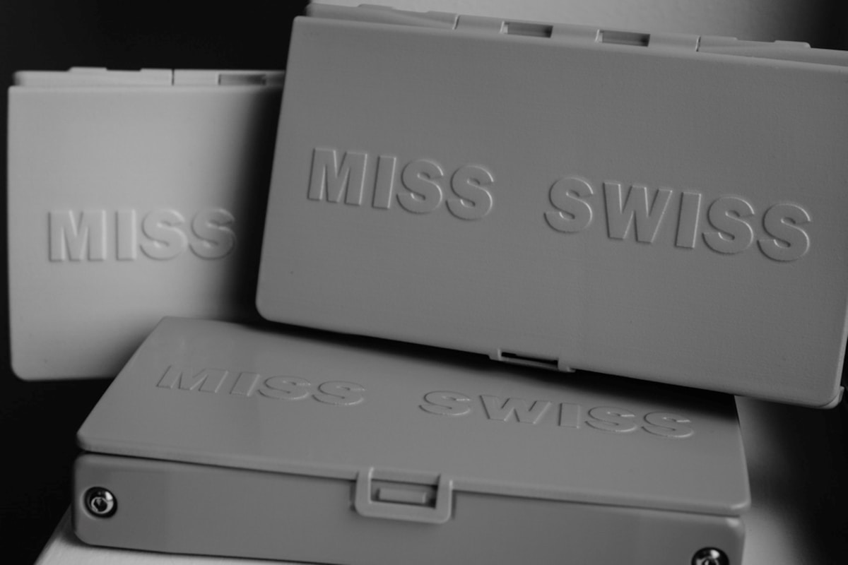 Boîtes grises avec l'inscription "MISS SWISS" en relief.
