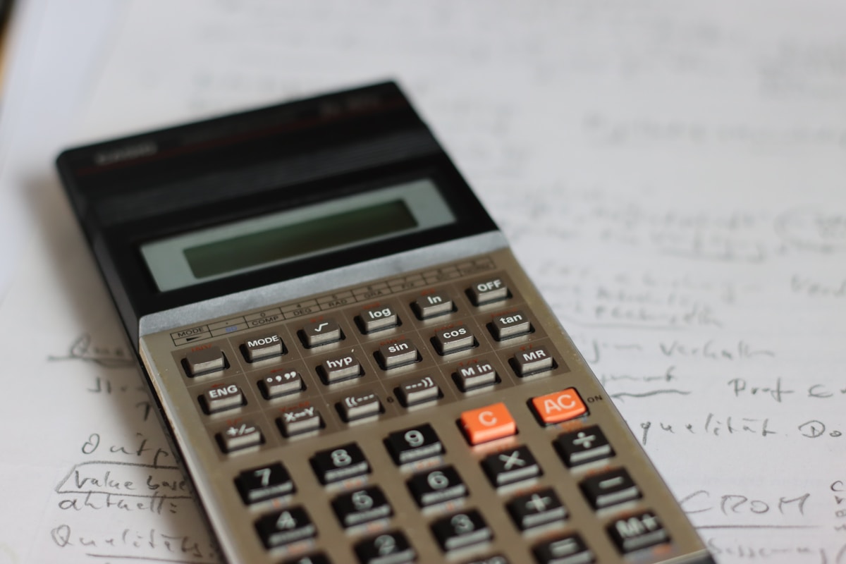 Calculatrice électronique avec boutons et écran LCD sur un bureau.