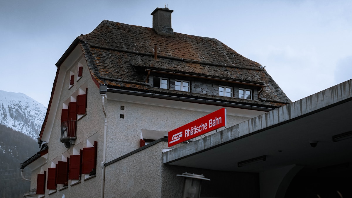 Bâtiment ancien en pierre avec toit en ardoise et enseigne de chemin de fer.