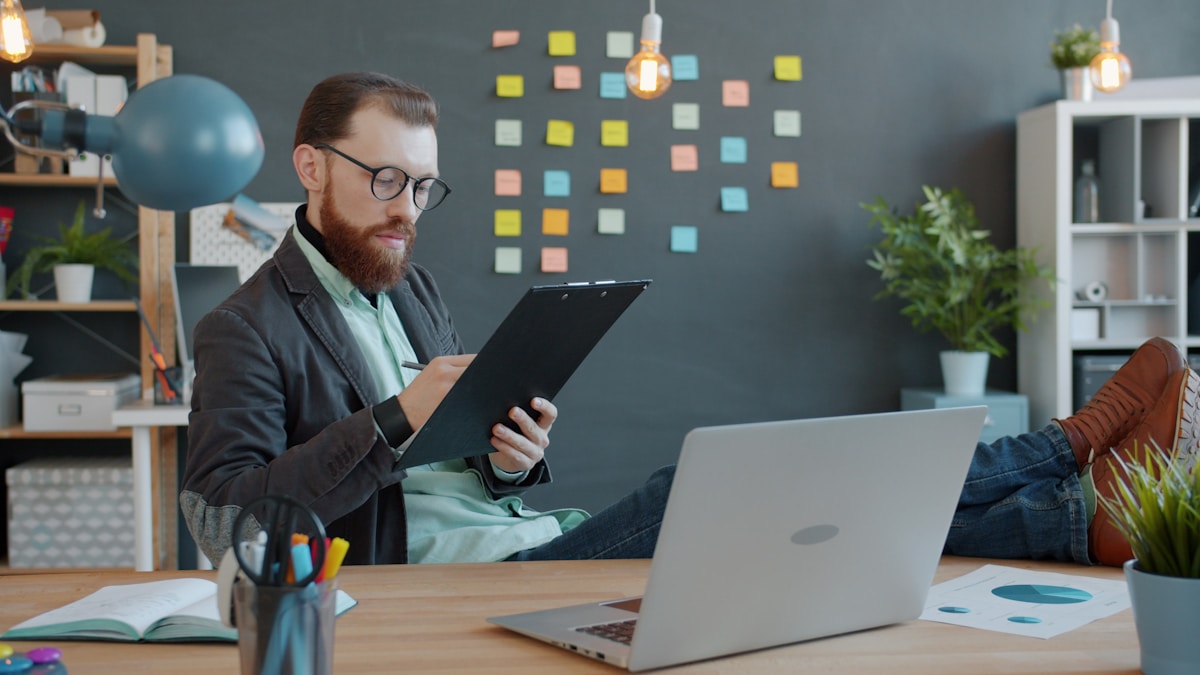 Homme barbu travaillant sur ordinateur portable dans un bureau créatif.