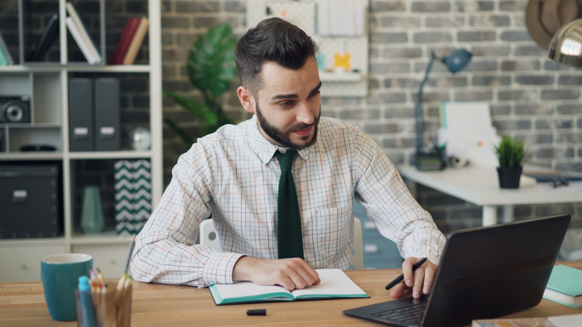 Homme d'affaires concentré travaillant sur son ordinateur portable dans un bureau.