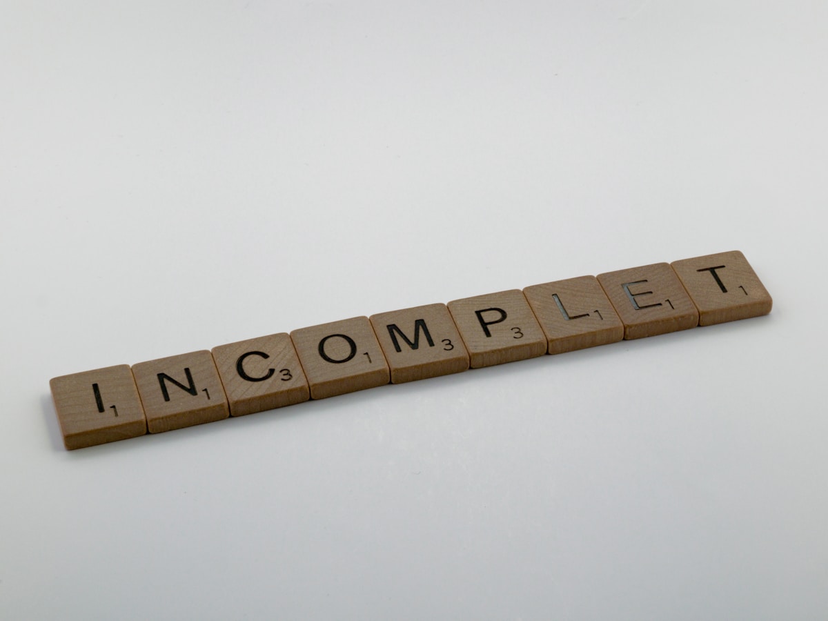 Lettres en bois formant le mot "INCOMPLETE".