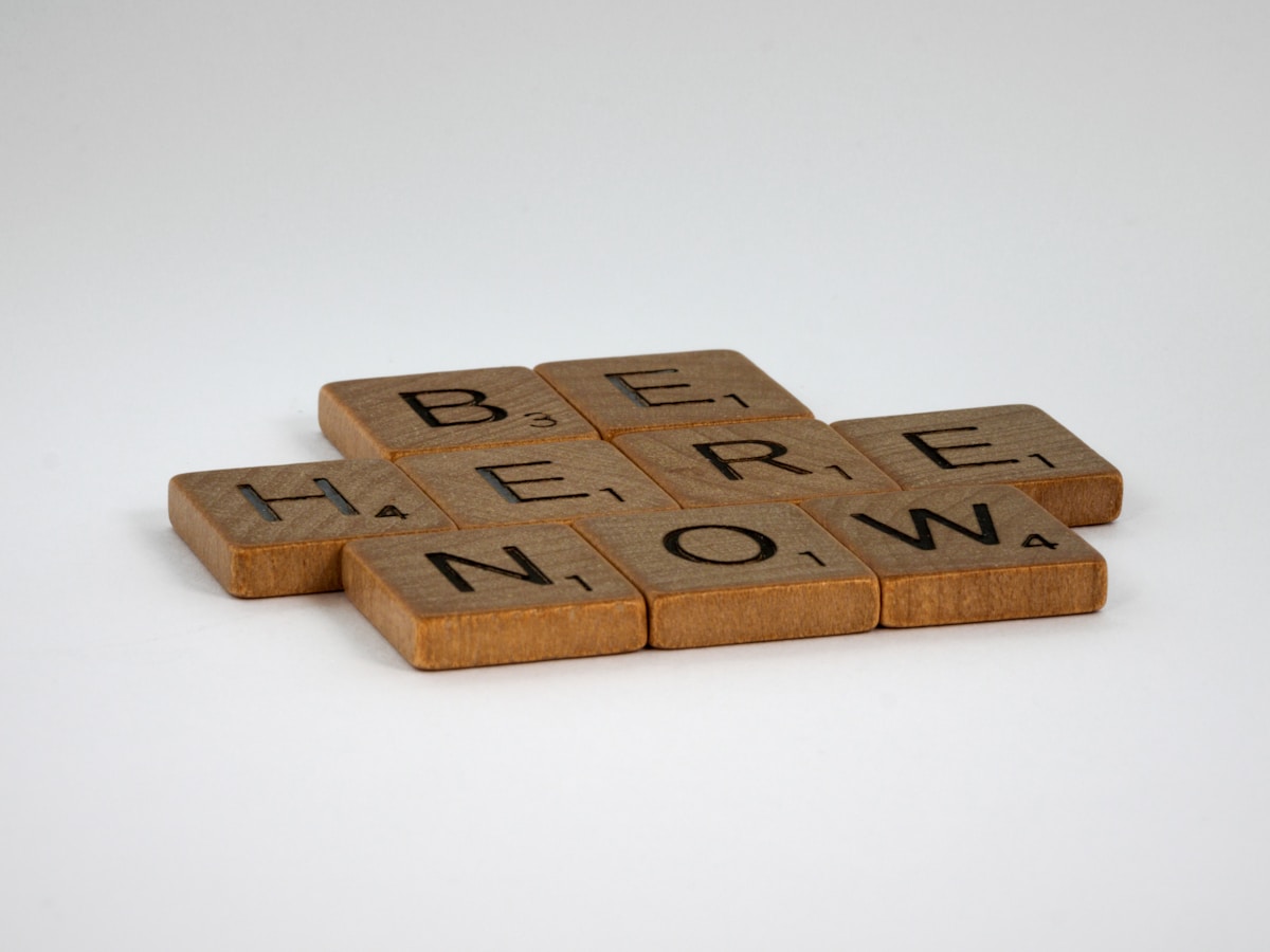 Lettres en bois formant le mot "Here now".