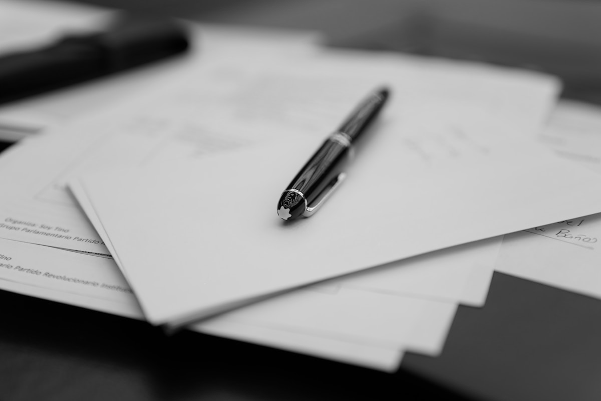Stylo sur documents administratifs en noir et blanc.