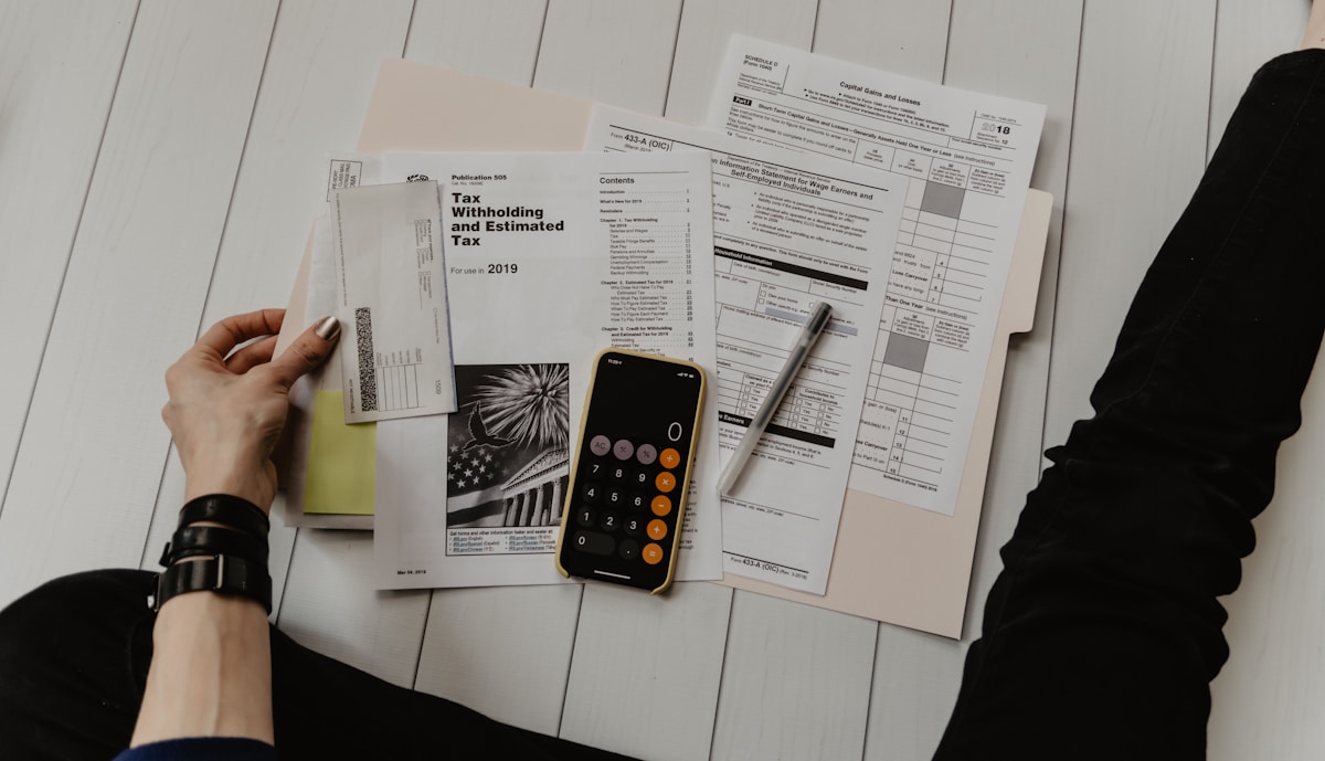 Documents fiscaux, calculatrice, stylo sur une surface en bois.