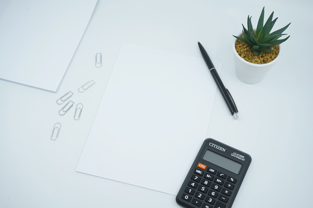 Bureau de travail avec papier, crayon et calculatrice.