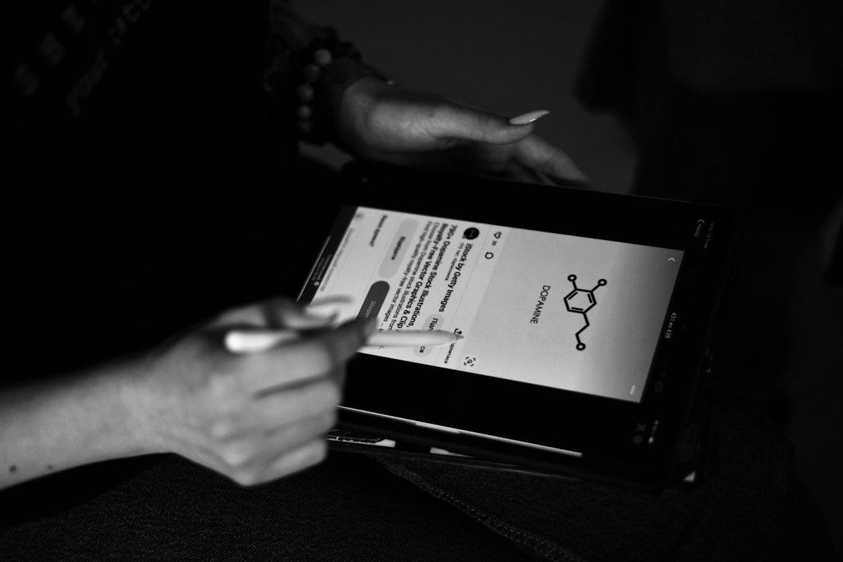 Mains tenant un document avec un symbole chimique en noir et blanc.