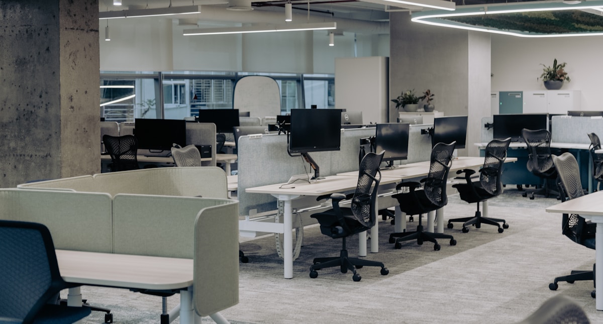 Espace de bureau moderne avec des postes de travail équipés d'ordinateurs.