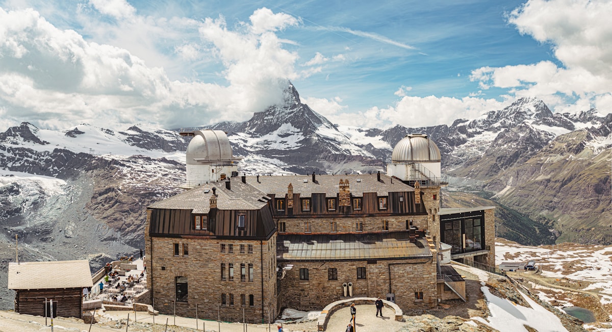 Gornergrat kulm hotel and matterhorn peak under a cloudy sky.