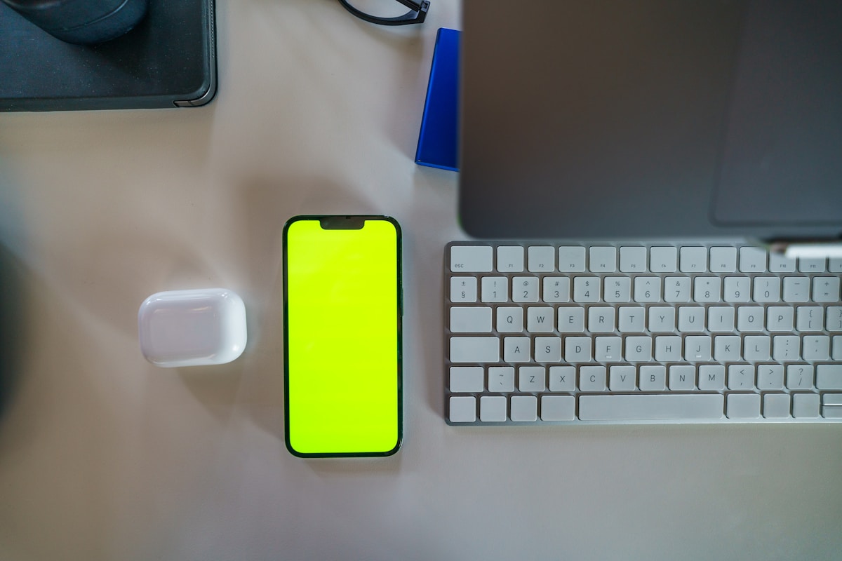 A cell phone sitting on top of a table next to a keyboard