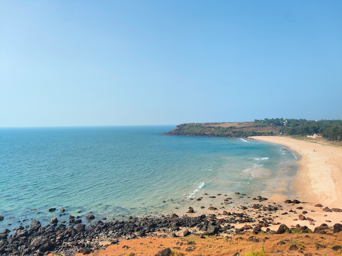 A scenic view of a sandy beach and calm ocean.