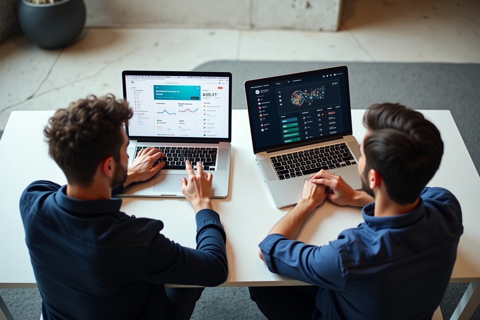 Two individuals analyzing data on laptop computers.