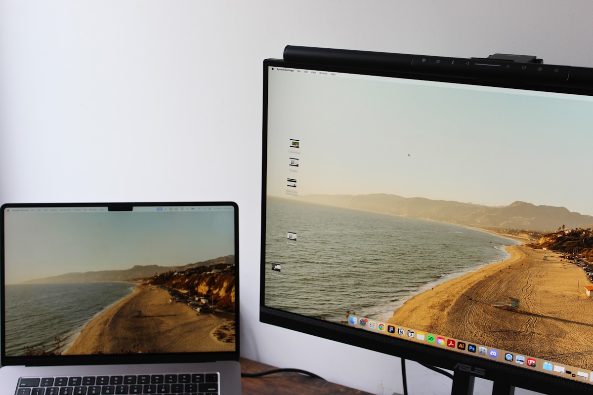 a laptop computer sitting on top of a desk next to a monitor