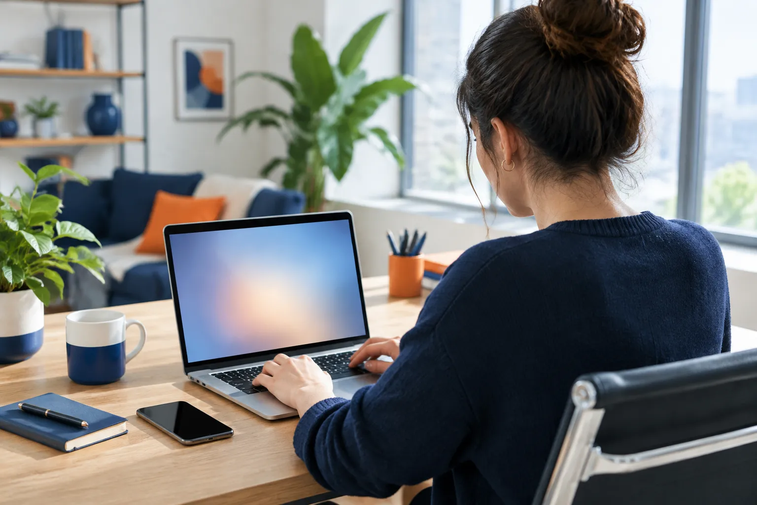 Woman working on laptop at home office desk