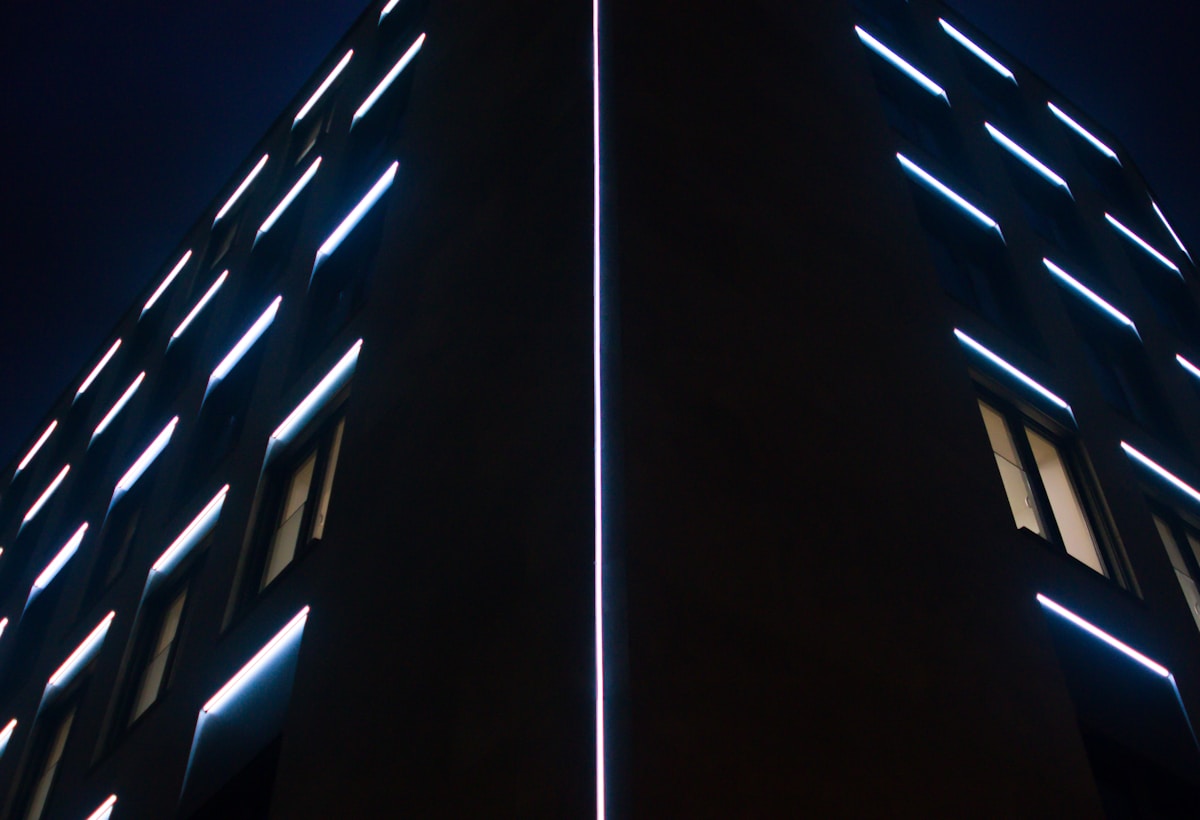 two tall buildings with lights on each of them