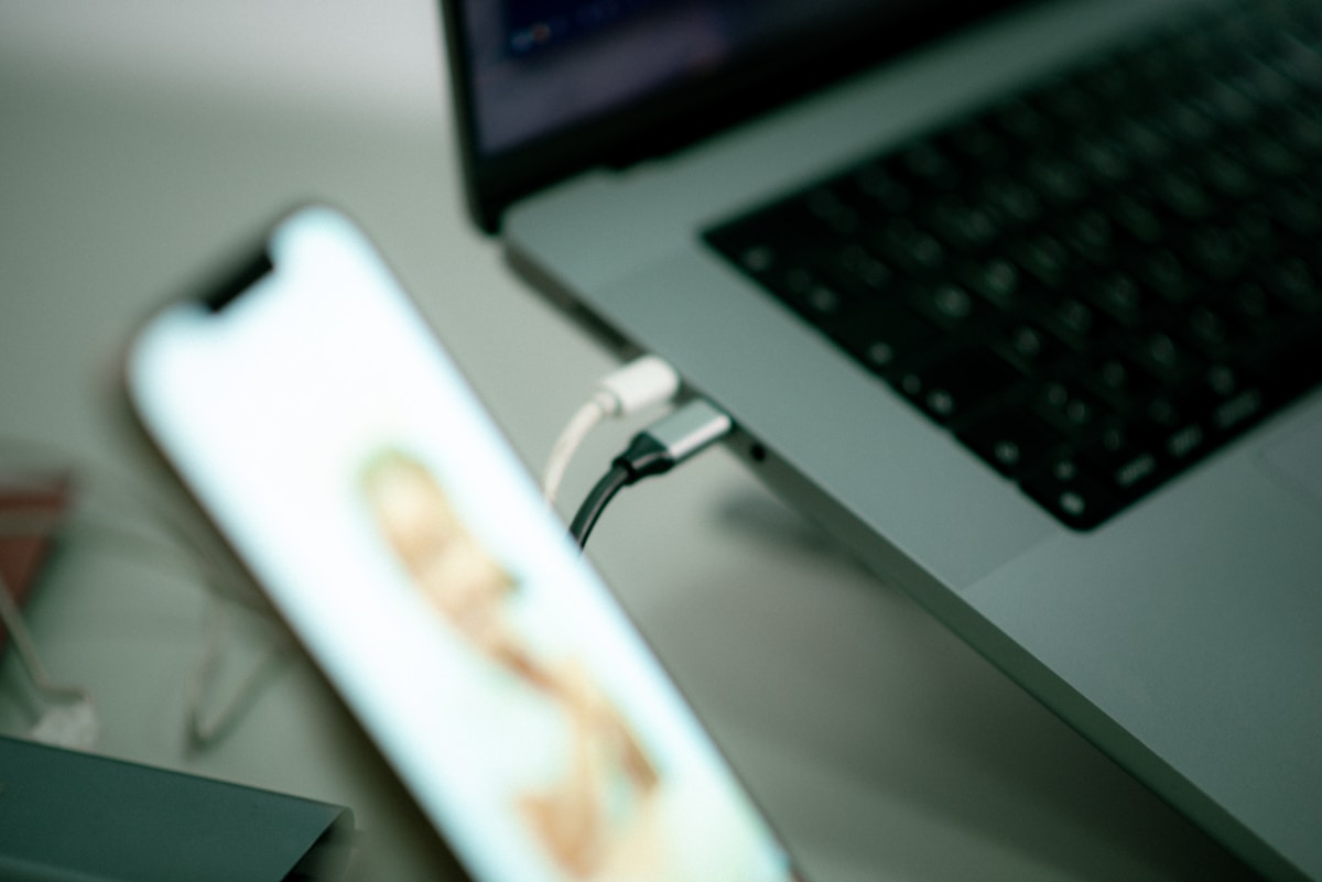 a close up of a cell phone near a laptop