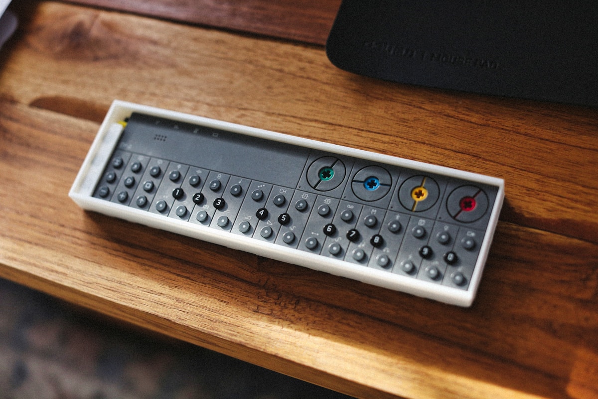 A synthesizer lies on a wooden table.