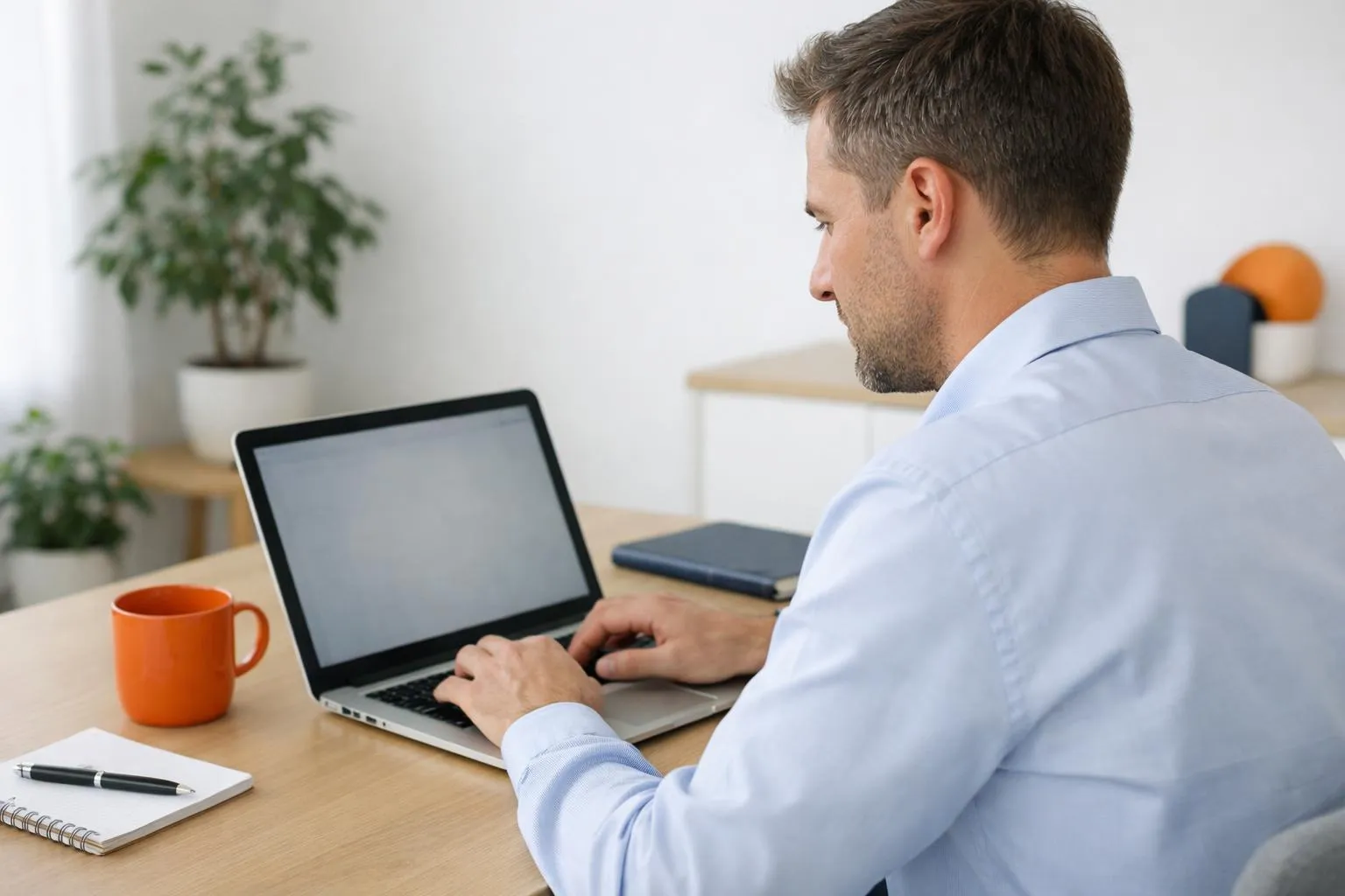A man working on a laptop in a home office.