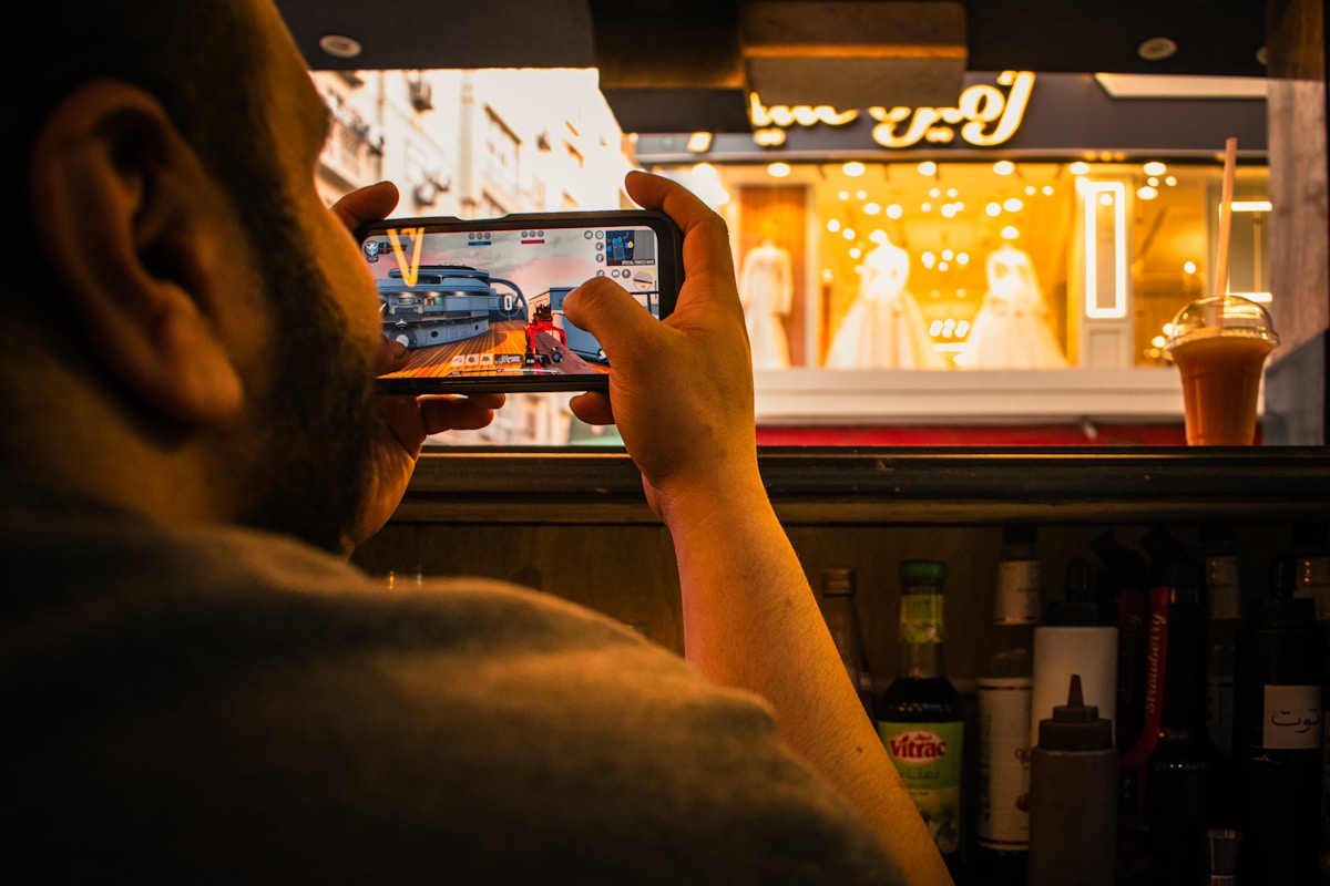 Man films a storefront window display with smartphone.