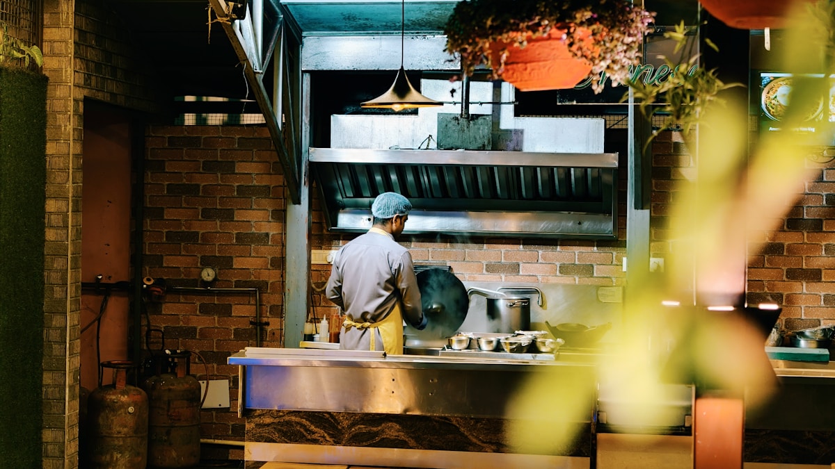 Chef working in a commercial kitchen at night.