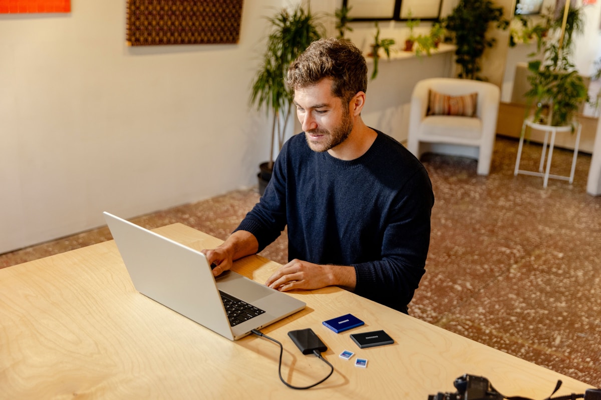 A man sitting at a table using a laptop computer