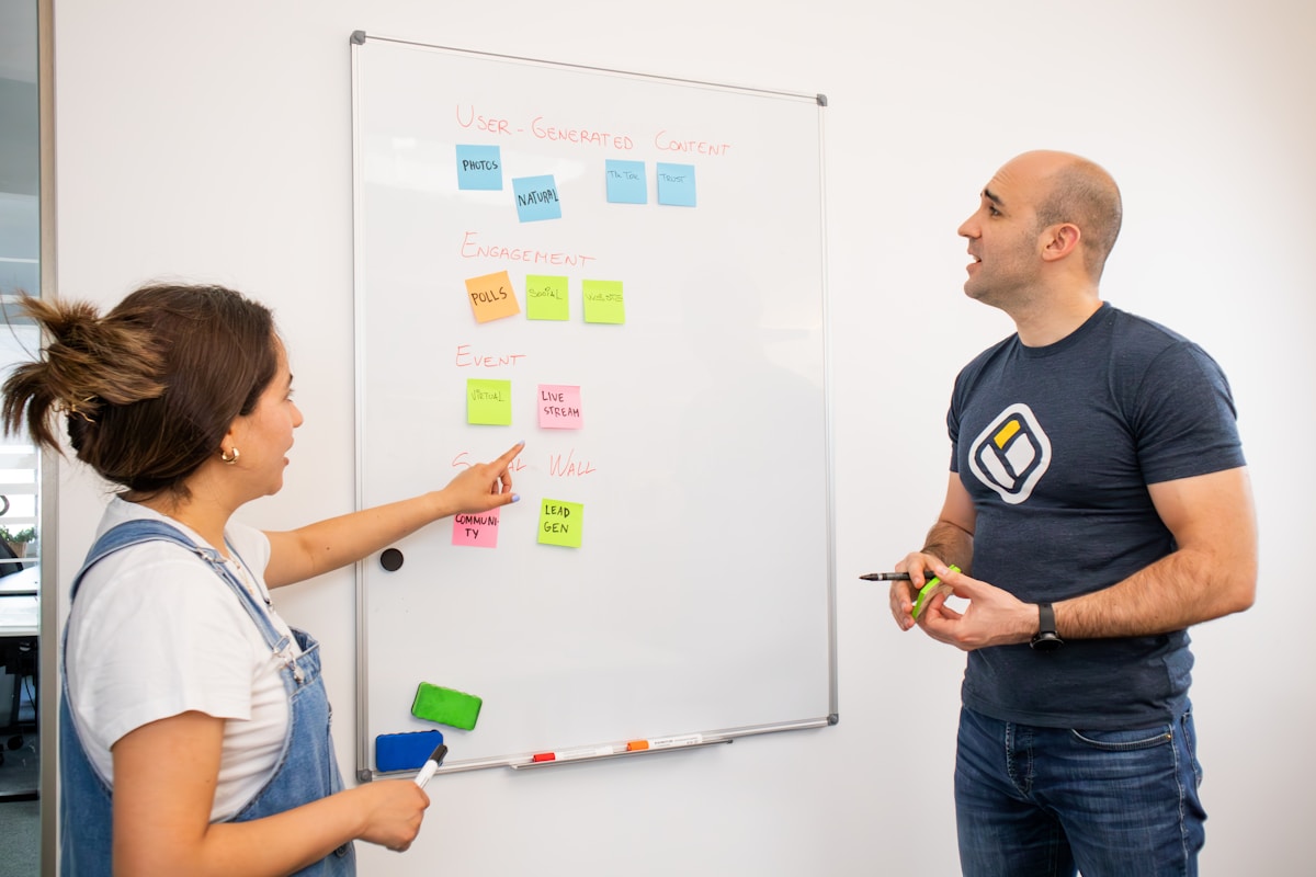a man and a woman standing in front of a white board