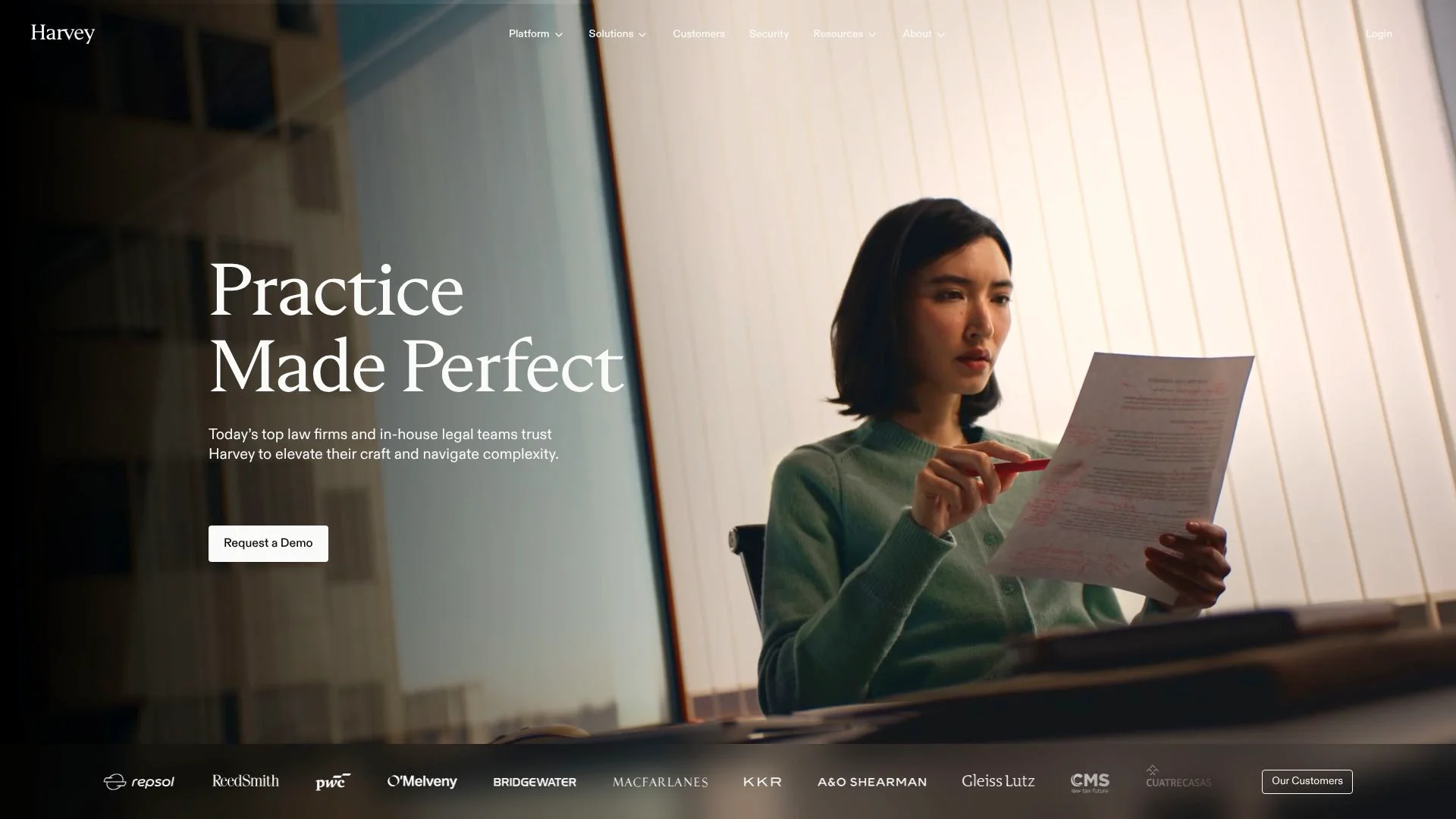 A woman in a green sweater reading a document intently.